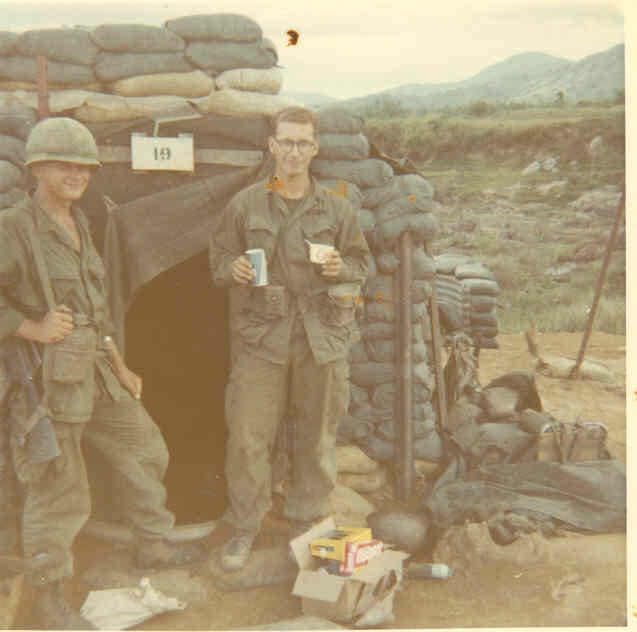 Two soldiers standing beside a sandbag bunker in Vietnam